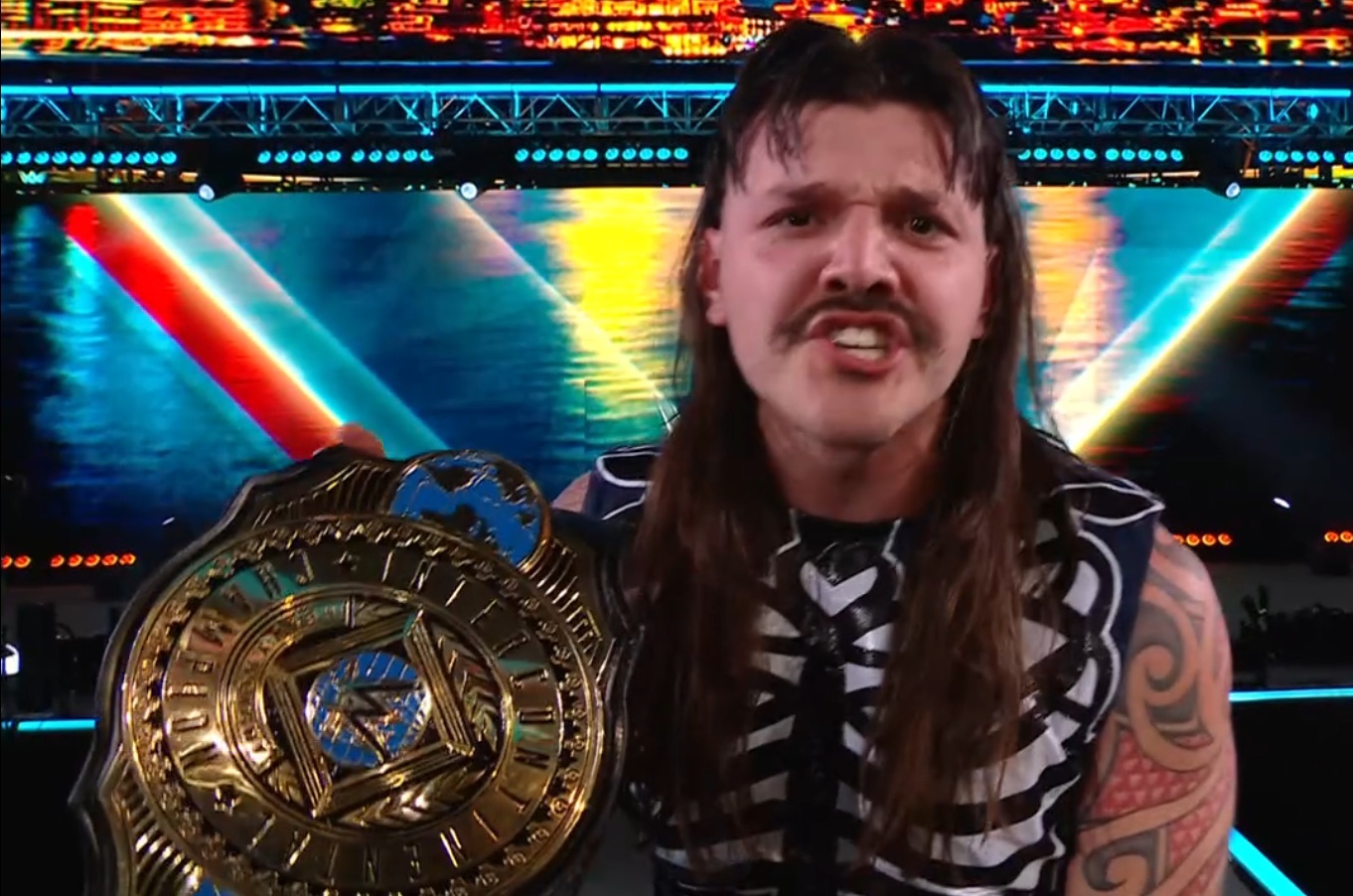 Dominik Mysterio enthusiastically celebrates his victory, holding a championship belt, while wearing a skeleton-themed outfit. The background features vibrant lights and colors, enhancing the celebratory atmosphere.